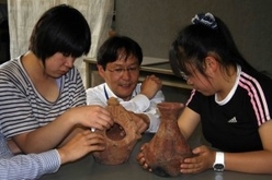 本物の土器に触っている子供たちの写真
